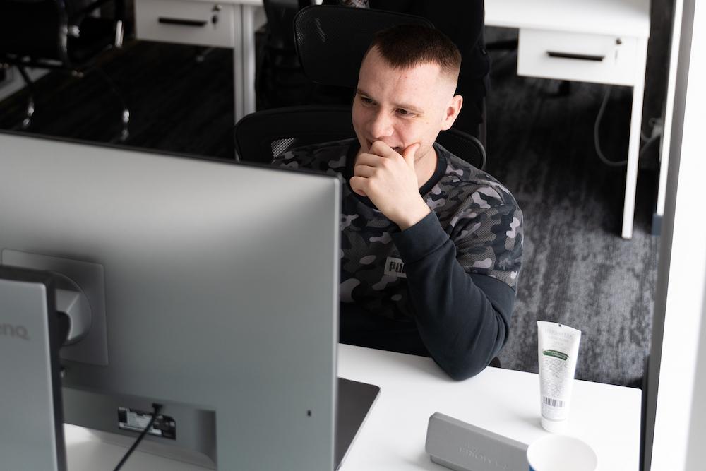 Serhii Shramko is sitting at a table with a computer